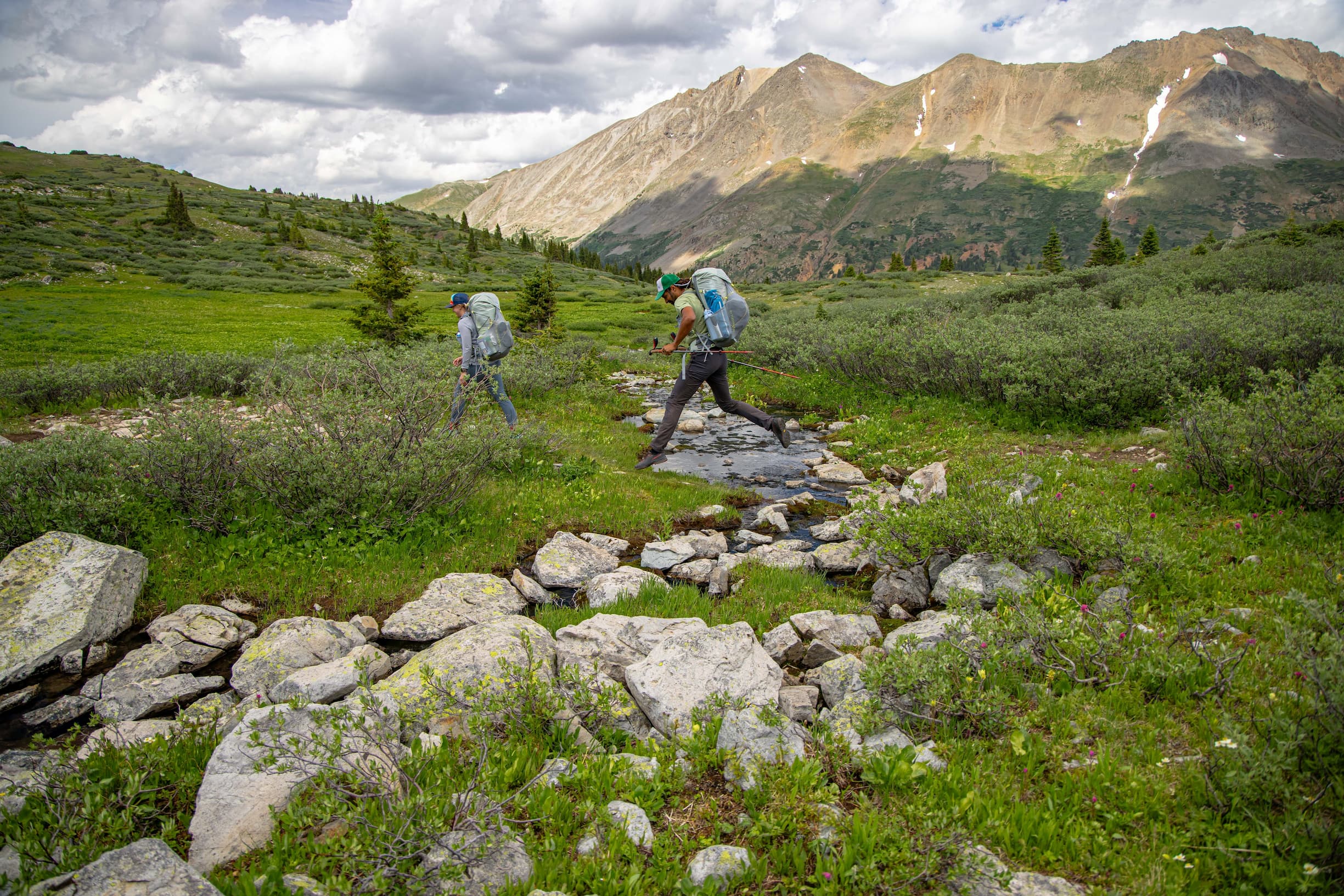 Hopping over a creek wearing sweetwater ul backpacks