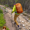 Person hiking on a trail with a large orange backpack