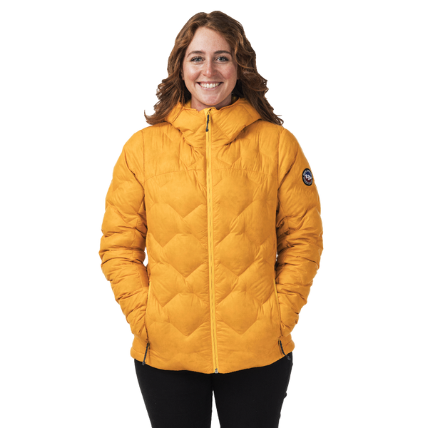 Person wearing a mustard yellow quilted jacket on a white background