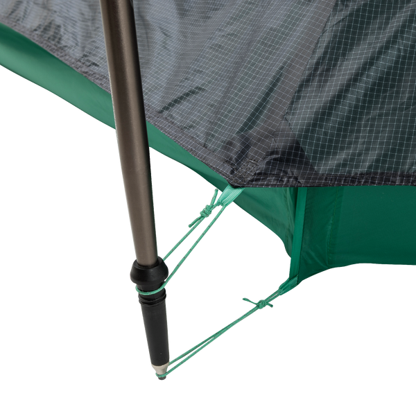 Close-up of a String Ridge VST 1.5 tent corner by Big Agnes, showing a black pole secured with green guy lines on reinforced, grid-patterned green and gray fabric—highlighting this ultralight shelter’s durability and detailed design.