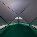 Inside view of a tent with green floor and gray walls