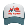 A white and teal trucker hat featuring a stylized red mountain and sun graphic above the words Big Agnes in bold red letters on the front panel.
