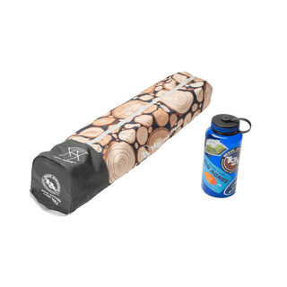 wood print camp table in carrying case next to a blue water bottle on a white background