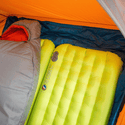 Piumino per tenda isolato mostrato come strato isolante tra il pavimento della tenda e i materassini